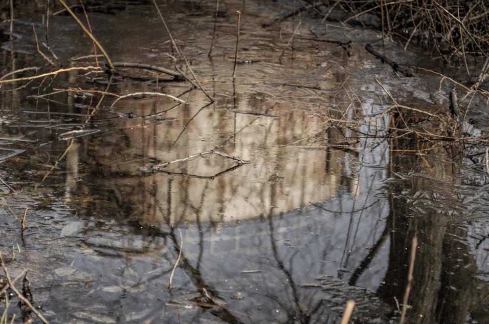 Old,,Rustic,Oil,Tanks,Or,Abandoned,Factory,Reflection,In,Polluted,