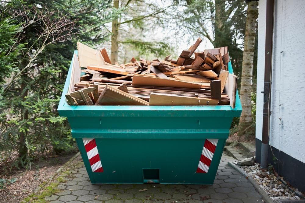 Green,Container,Filled,With,Wood,,Next,To,A,House