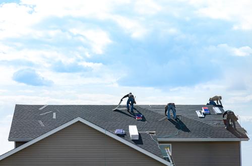 4,Construction,Workers,Fixing,Roof,Against,Clouds,Blue,Sky.,Roofer
